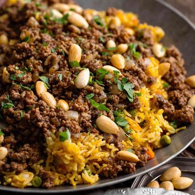أرز متبل مع البازلاء والجزر واللحم المفروم، مرشوش بالمكسرات المحمصة
